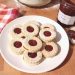 Des petits biscuits sablés rond à la confiture de fraise dans une assiette
