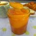 Pot de confiture de pêche de vigne maison avec une cuillère, servi avec un croissant et un café